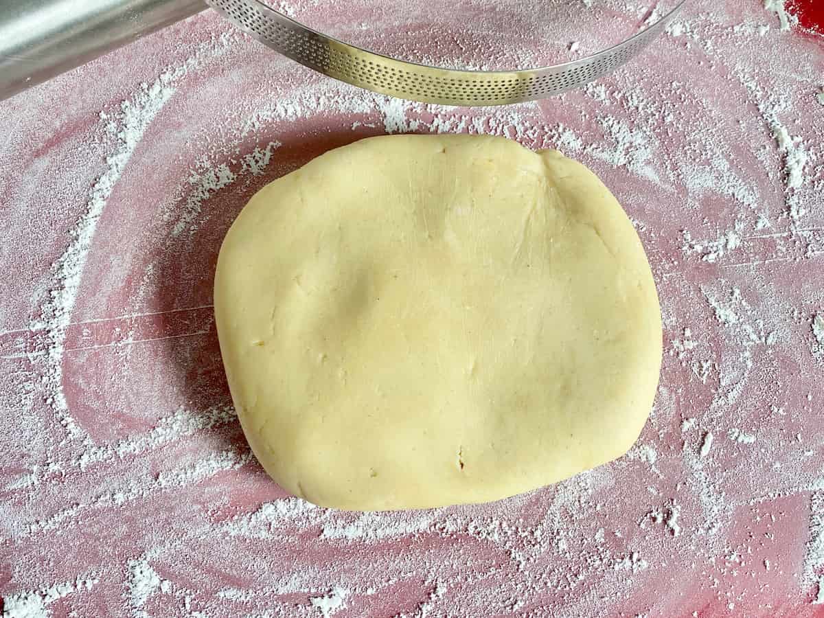 dough ball on floured surface with a tart ring
