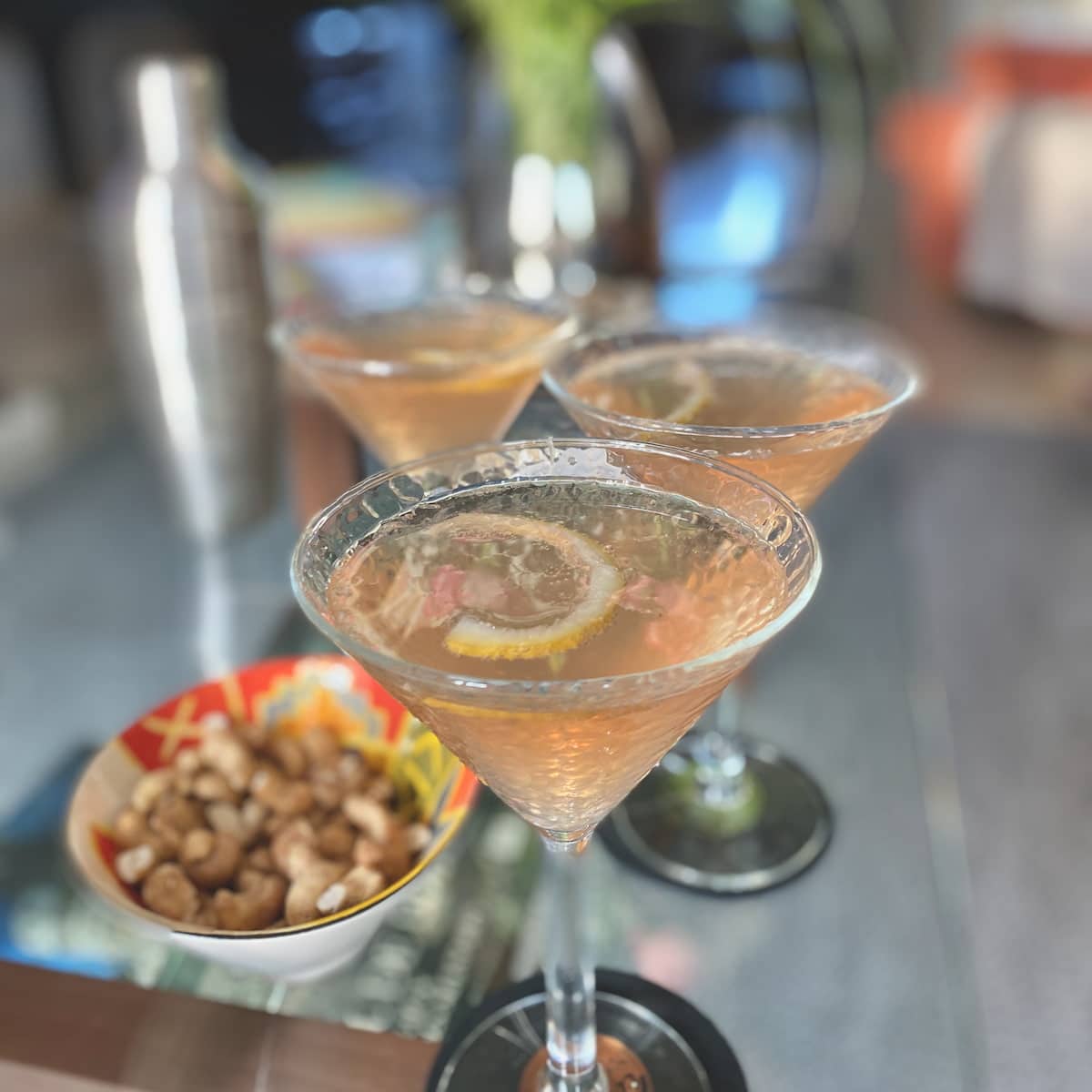 martini glasses of pink fizz garnished with lemon rind, a variation to the classic French 75 cocktail