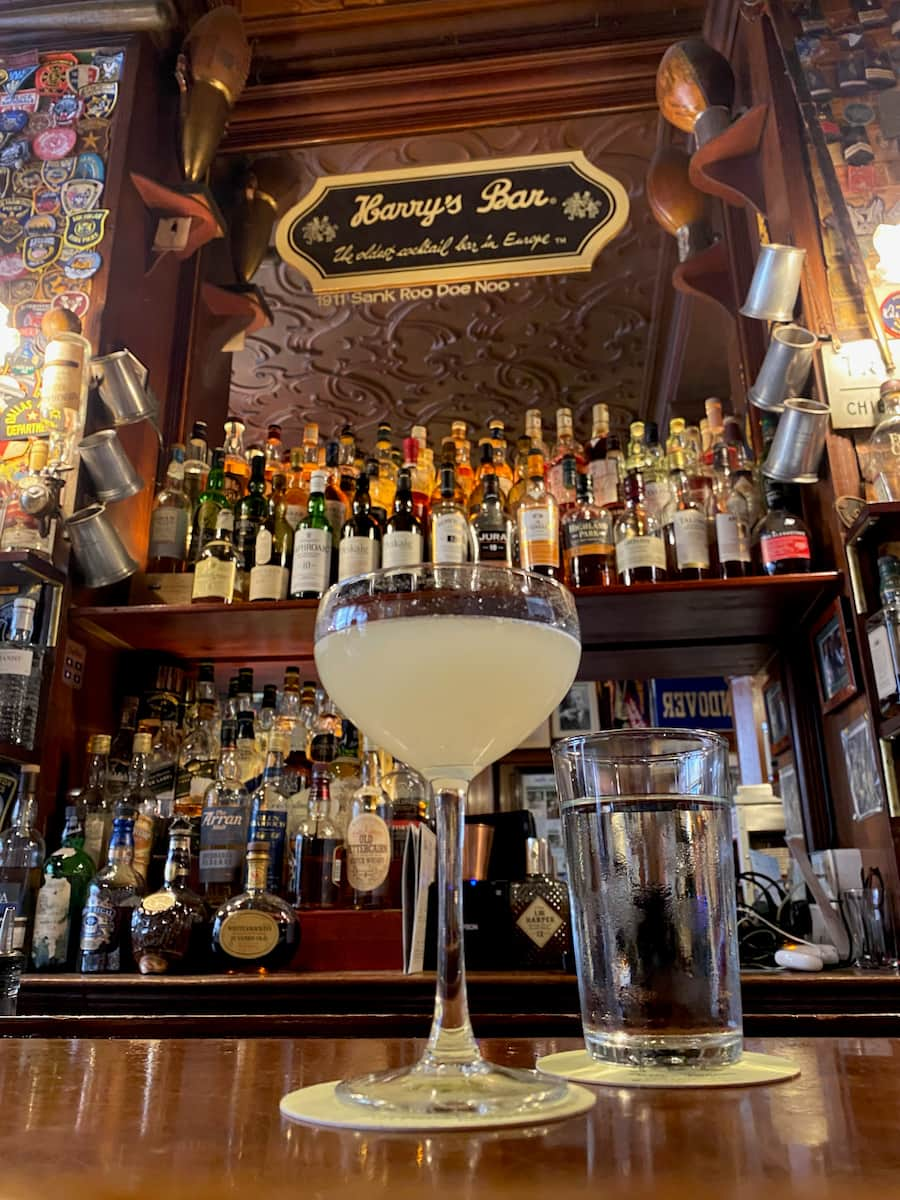 Champagne coupe in a bar with a cloudy lemon cocktail