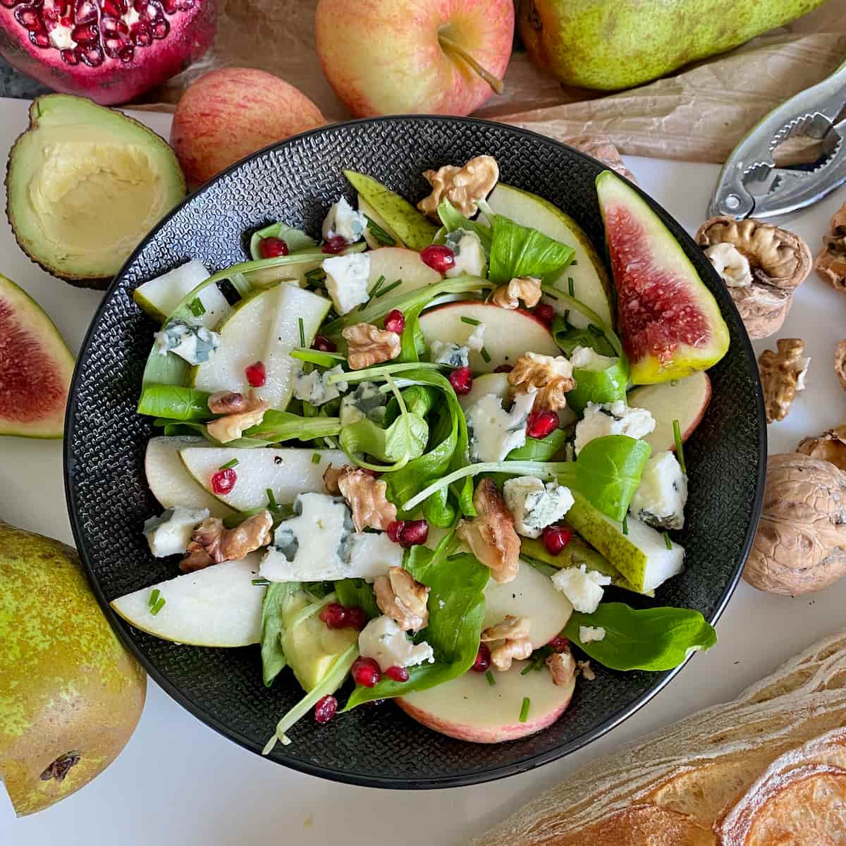blue cheese crumbled into a green salad with pear, apple and walnuts