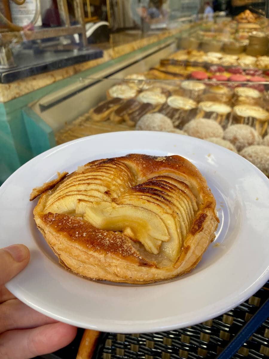 holding a puff pastry apple tart in. Paris at a bakery