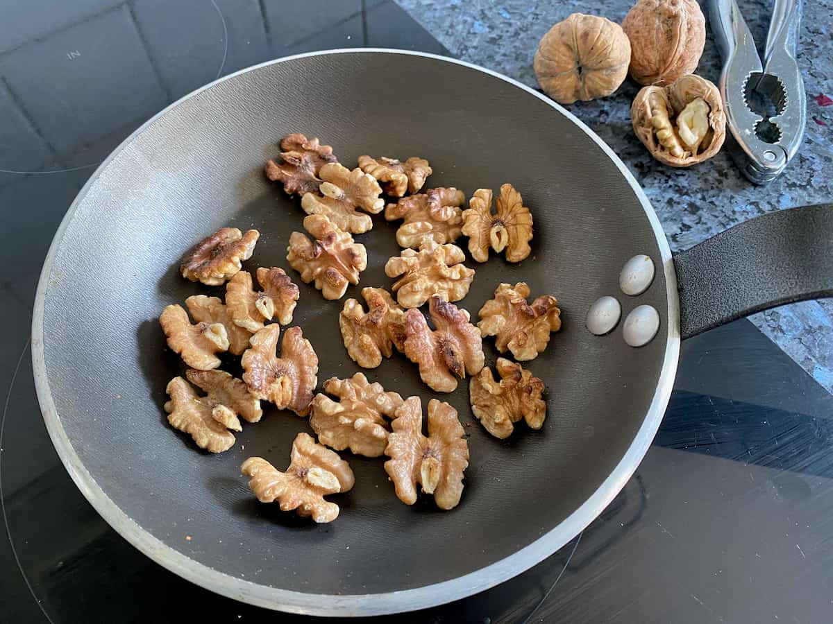 dry frying walnut kernels in a frying pan to toast them