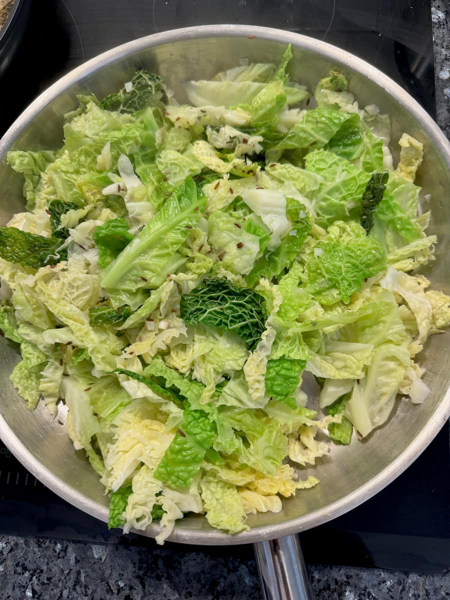 large pan of sautéed Savoy cabbage leaves, tossed in caraway seeds
