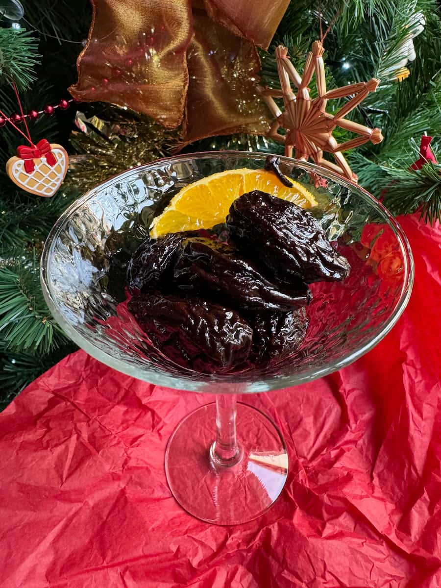 cocktail glass filled with juicy poached prunes in red wine, orange and spices