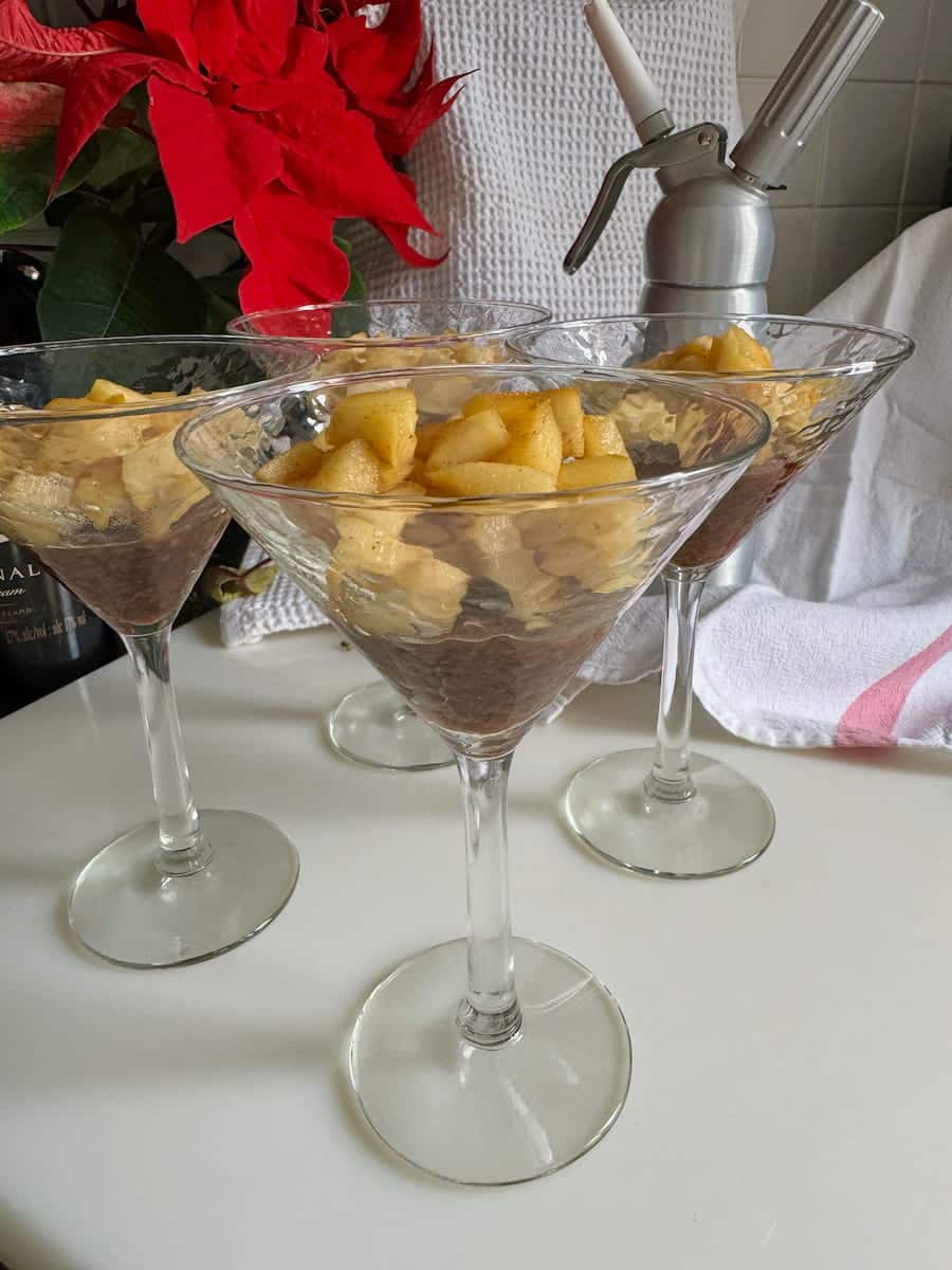 caramel apple chunks in glasses next to a siphon to make cream