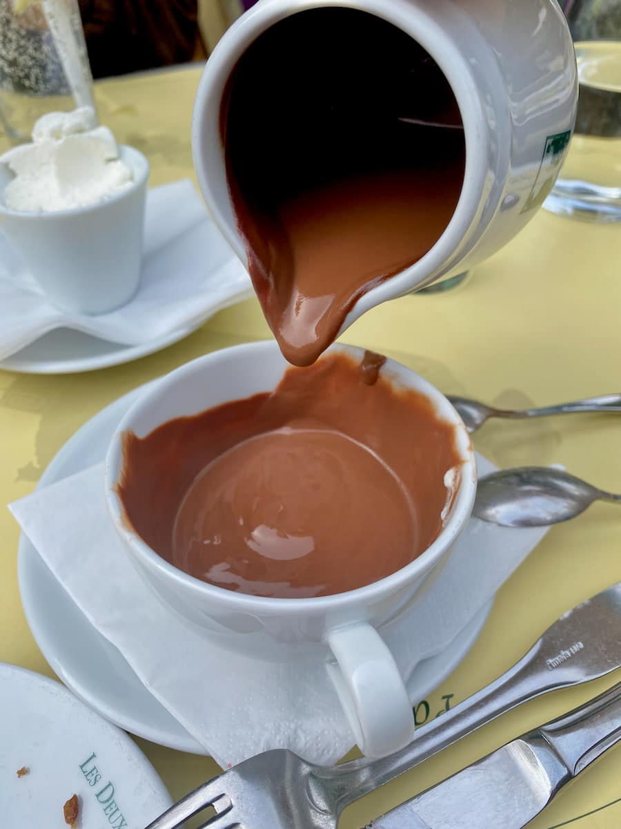 pouring extra thick hot chocolate from a jug into a cup in Paris