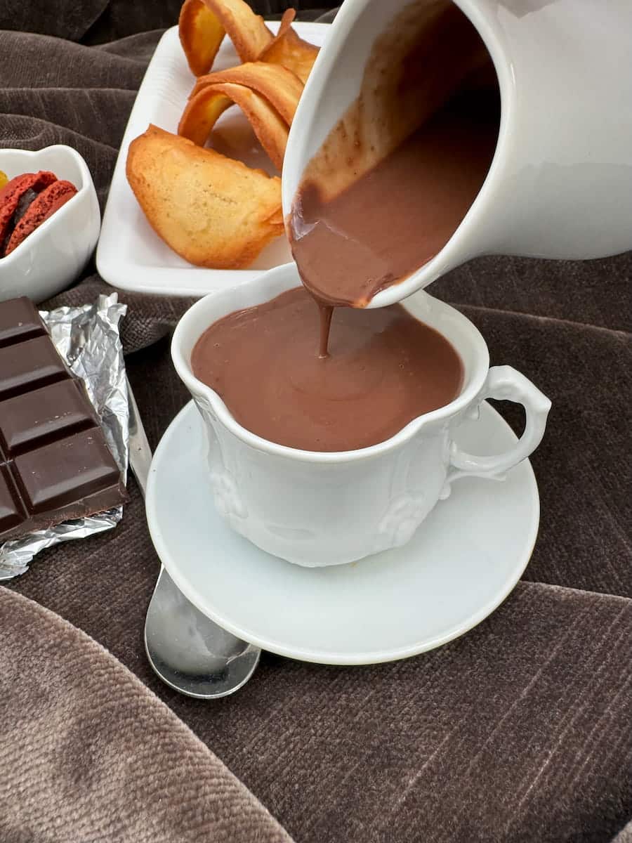 pouring thick hot chocolate from a porcelain jug