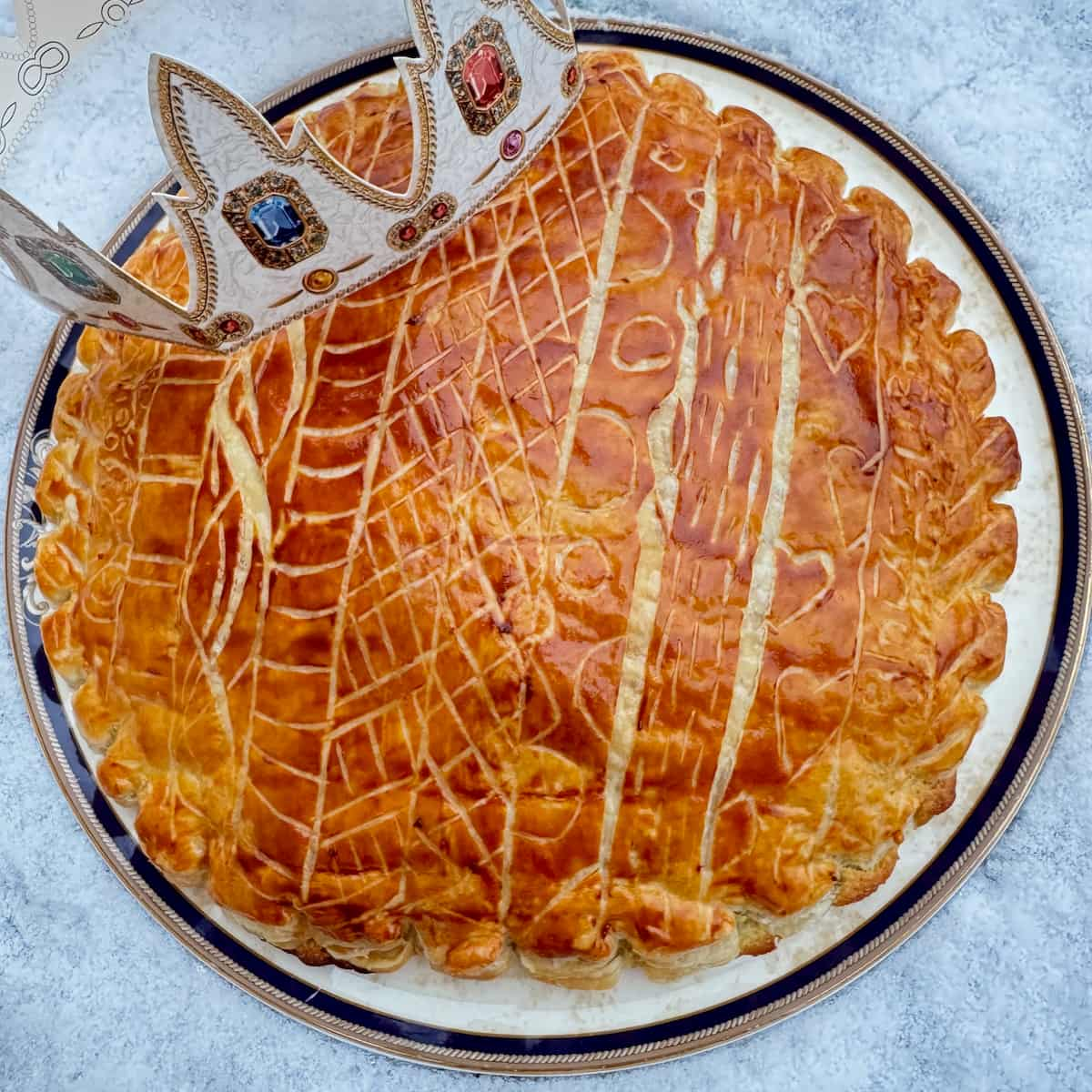 galette des rois French puff pastry almond cake glazed and decorated with a paper crown