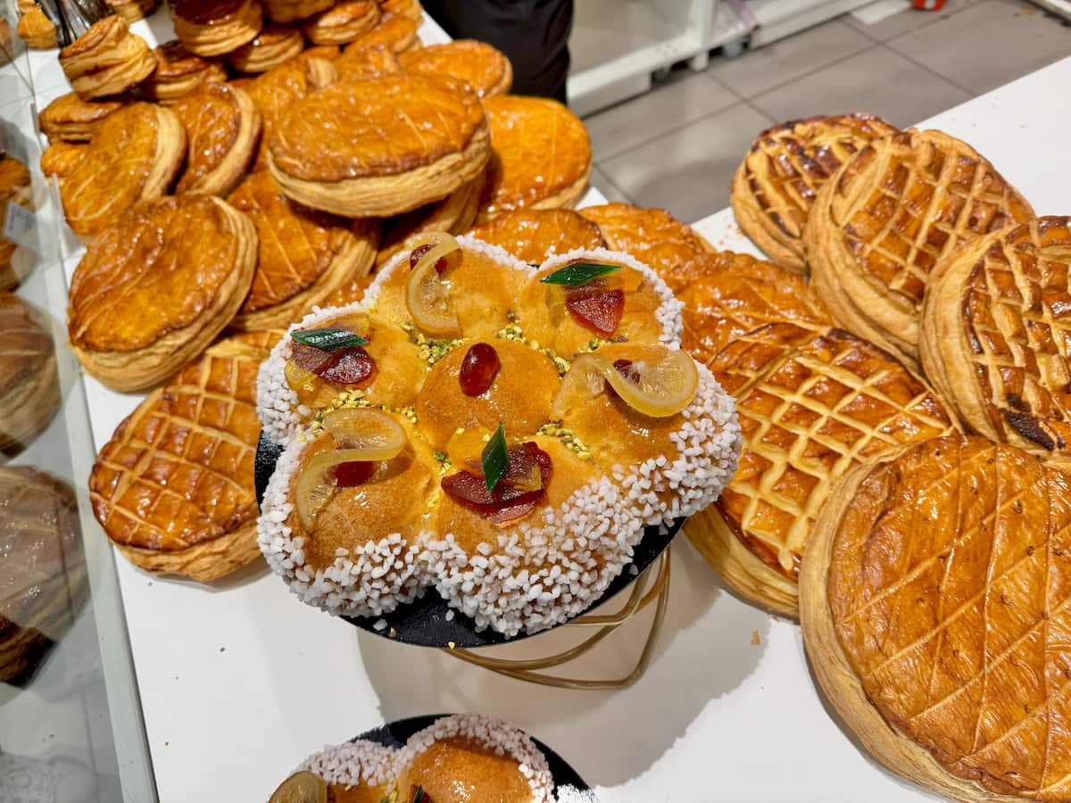pile of galettes de rois in a Paris bakery and a brioche studded with glazed fruits