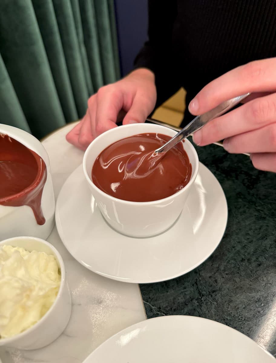 stirring a cup of extremely thick dark hot chocolate in a Parisian café