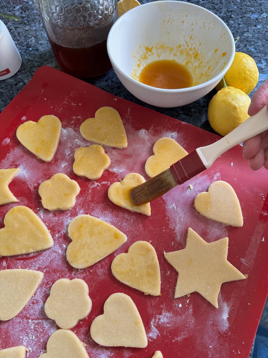 brushing on a honey glaze with egg yolk to cookies