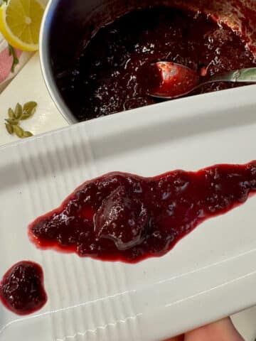 cherry sauce on a plate with a large sour cherry in the middle