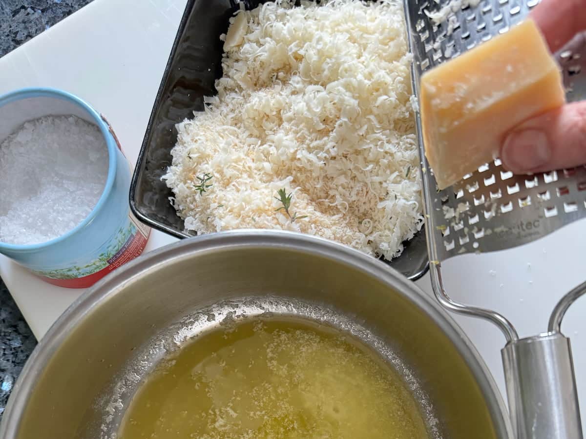 grating a block of fresh parmesan cheese into breadcrumbs