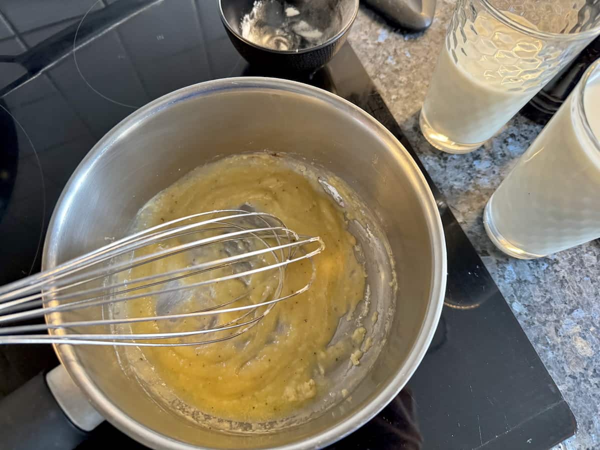 whisking melted butter with flour to make a basic white sauce