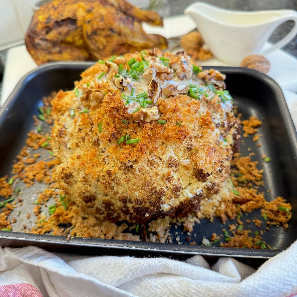 whole cauliflower roasted in oven topped with breadcrumbs and cheese