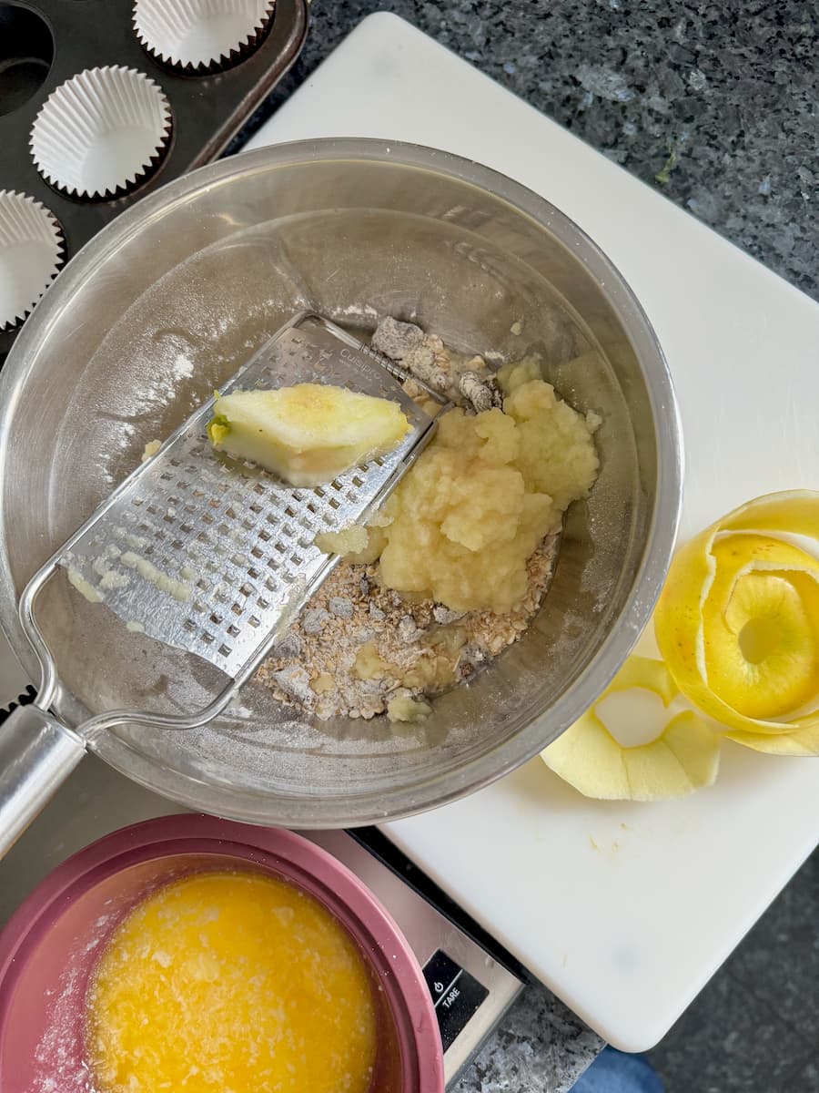 bowl of flour, oats and bran with sultanas and a whole grated apple