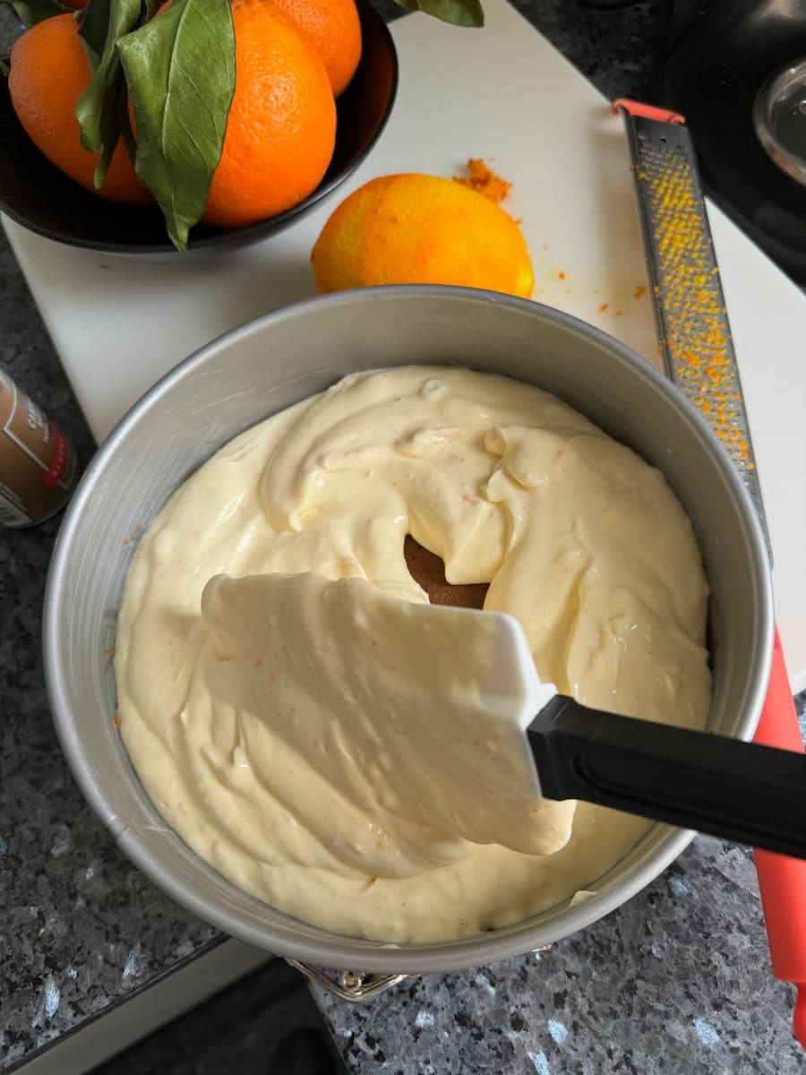 layering cream cheese with creme fraiche over a biscuit base in a tin