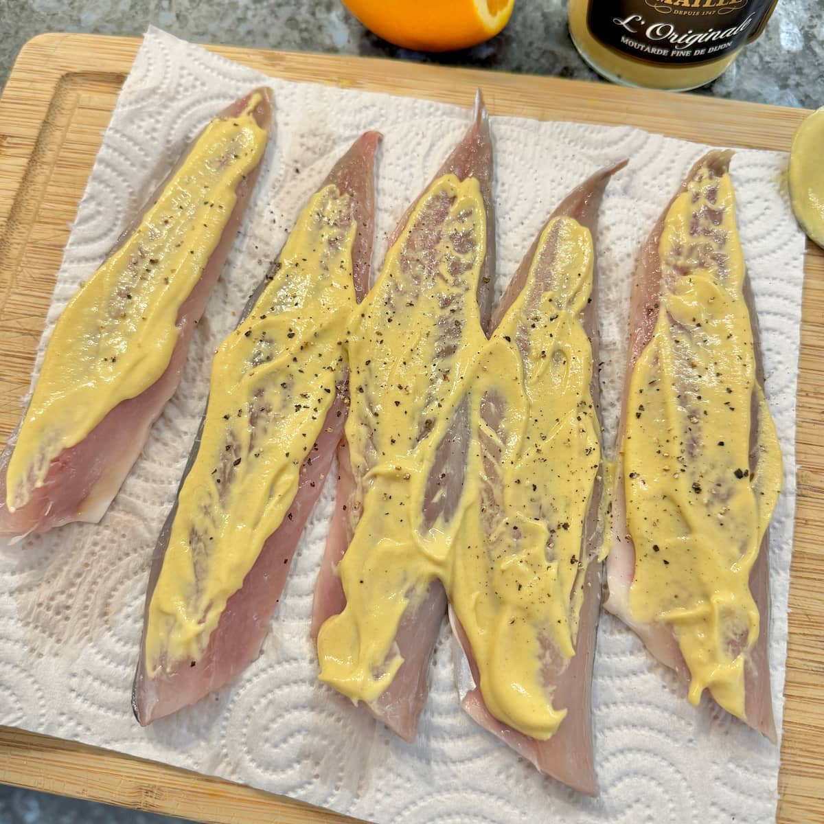 fresh fish fillets spread with Dijon mustard