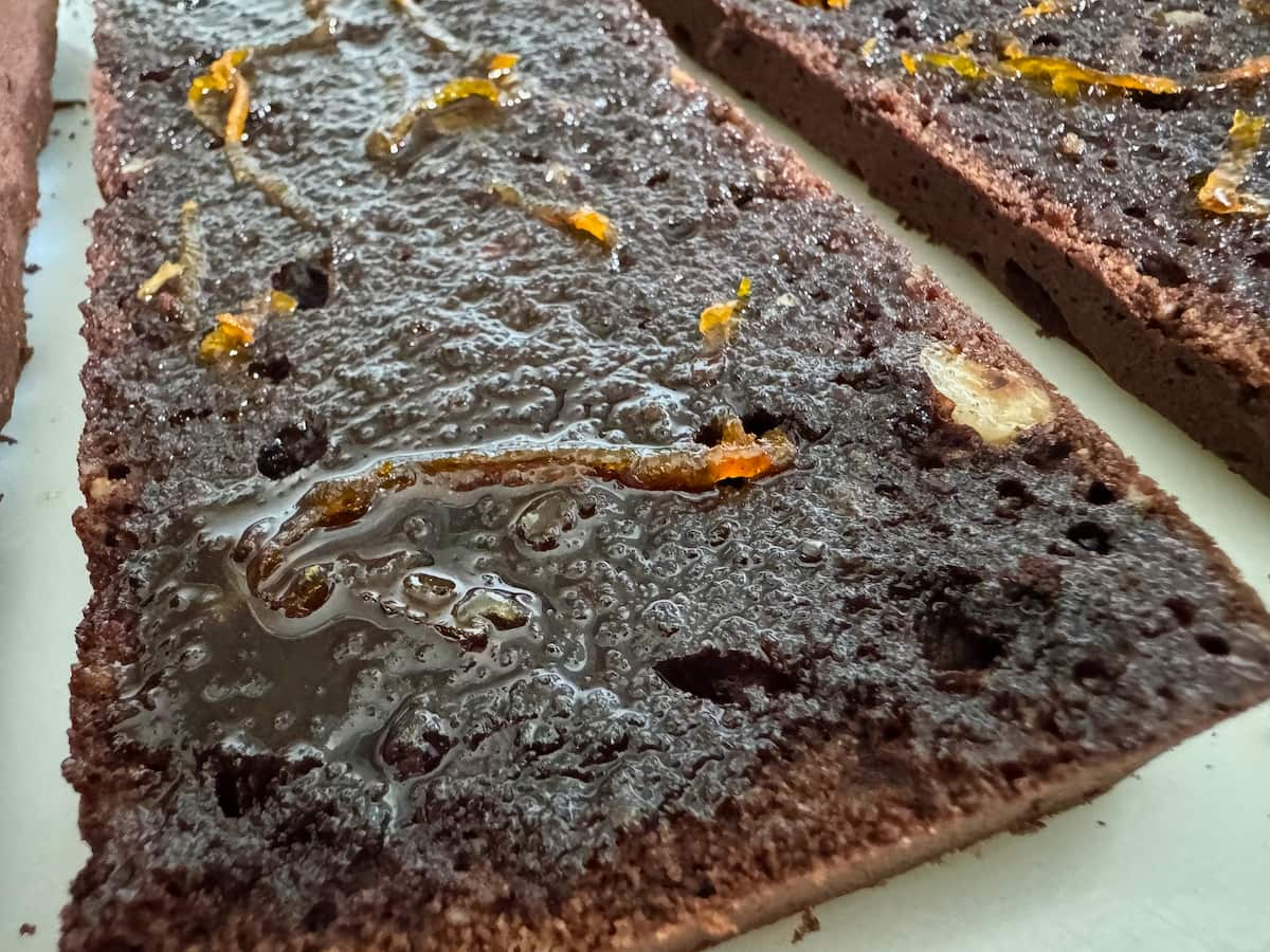 close up of a chocolate cake layer brushed with orange syrup