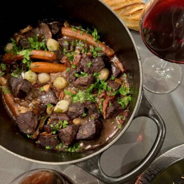 large crock pot with French beef stew in red wine, known as Boeuf Bourguignon