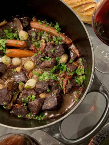 large crock pot with French beef stew in red wine, known as Boeuf Bourguignon