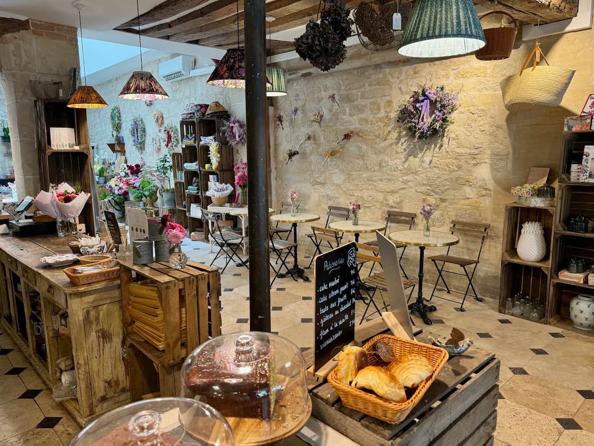 coffee and flower shop in Paris with floral decor and croissants and cakes on the counter