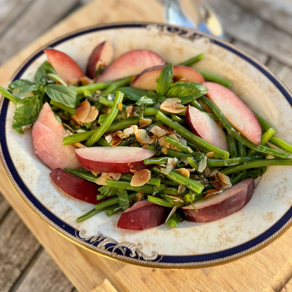 french green beans sauteed in a salad with a fresh peach