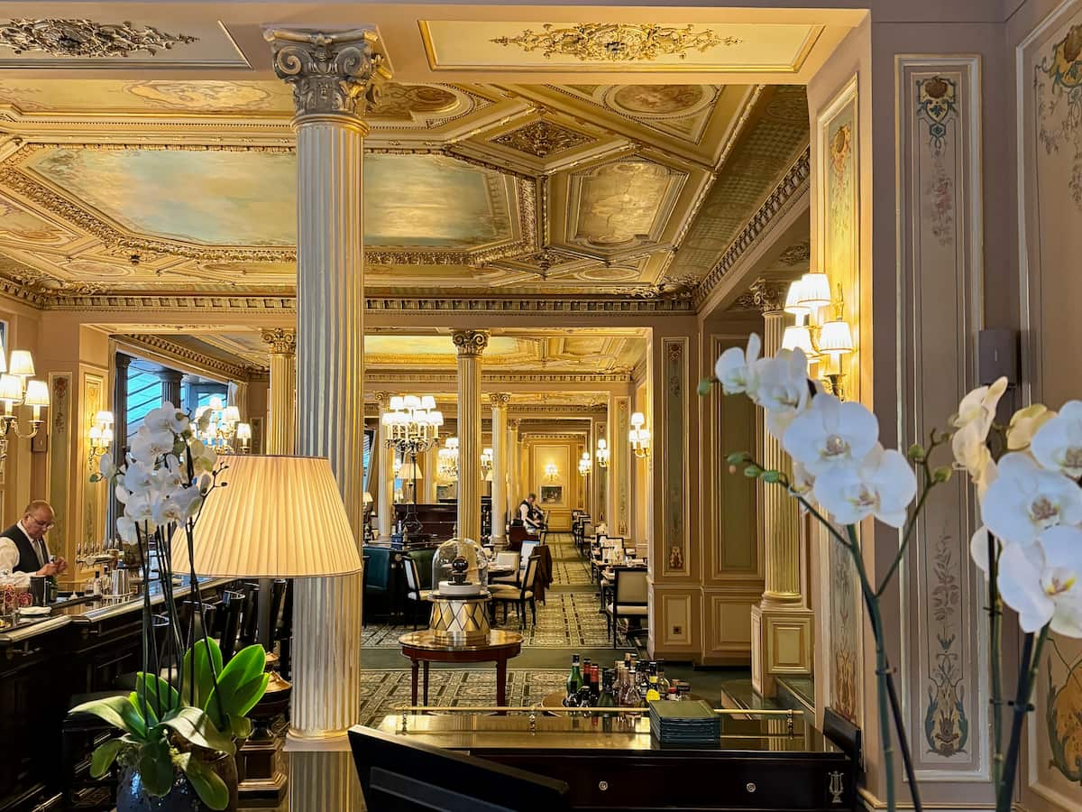 large dining area of le café de la paix in Paris with ornate decor and corinthian pillars