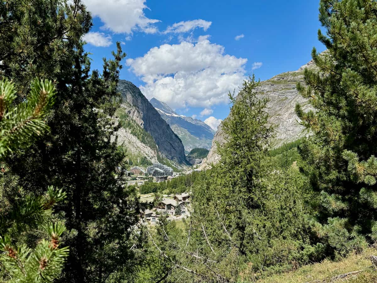 high mountain view in the French alps in summer with green trees and snow in the mountains