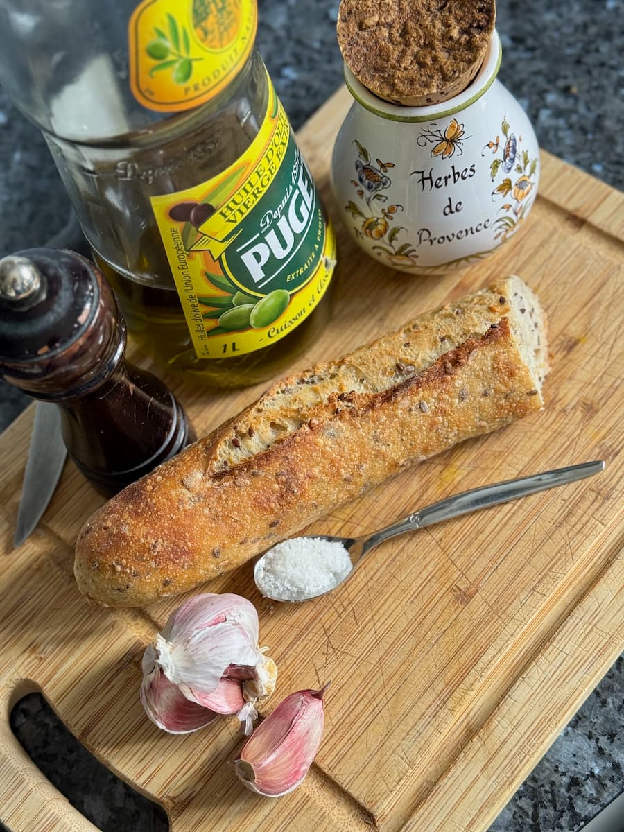 olive oil, half a French baguette with grains, salt, pepper, Herbes de Provence and a fresh clove of garlic