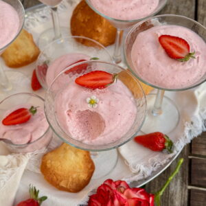 long-stemmed cocktail glasses filled with light and fluffy strawberry mousse topped with strawberries and served with French tuile cookies