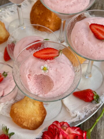 long-stemmed cocktail glasses filled with light and fluffy strawberry mousse topped with strawberries and served with French tuile cookies