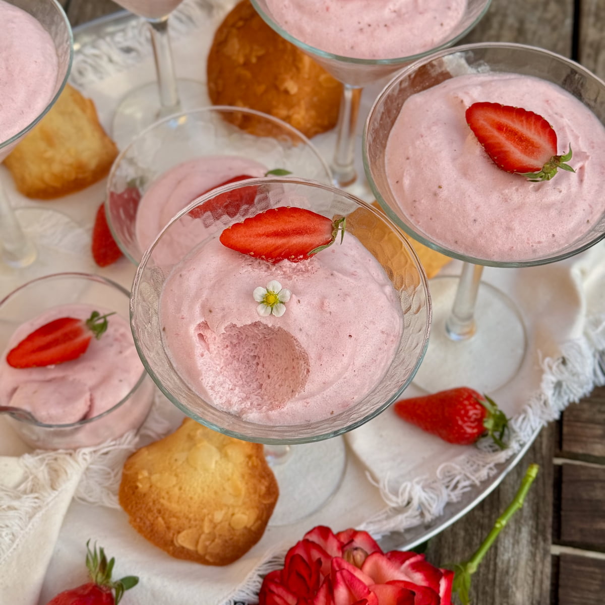 long-stemmed cocktail glasses filled with light and fluffy strawberry mousse topped with strawberries and served with French tuile cookies