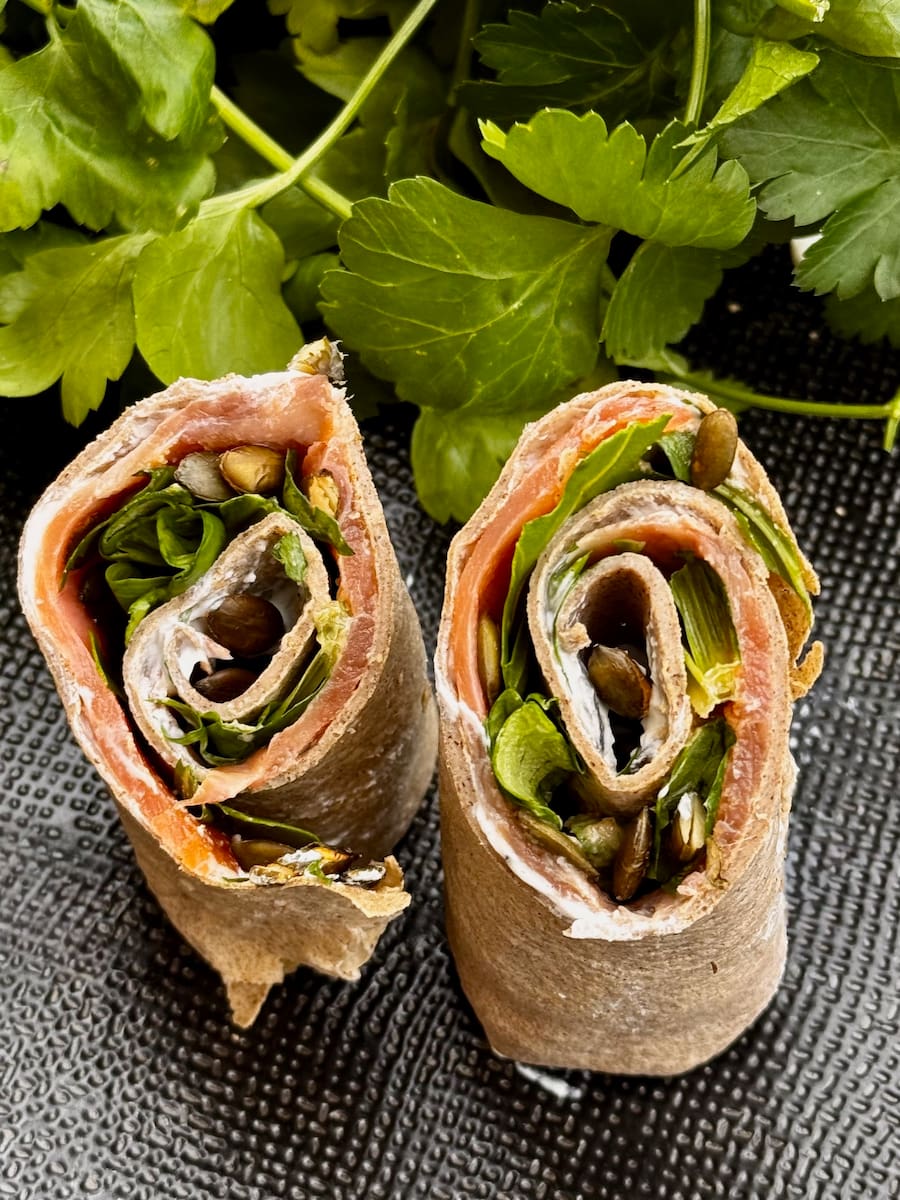 free-standing rolled wraps made of buckwheat flour and filled with smoked salmon, cream cheese, greens and toasted seeds