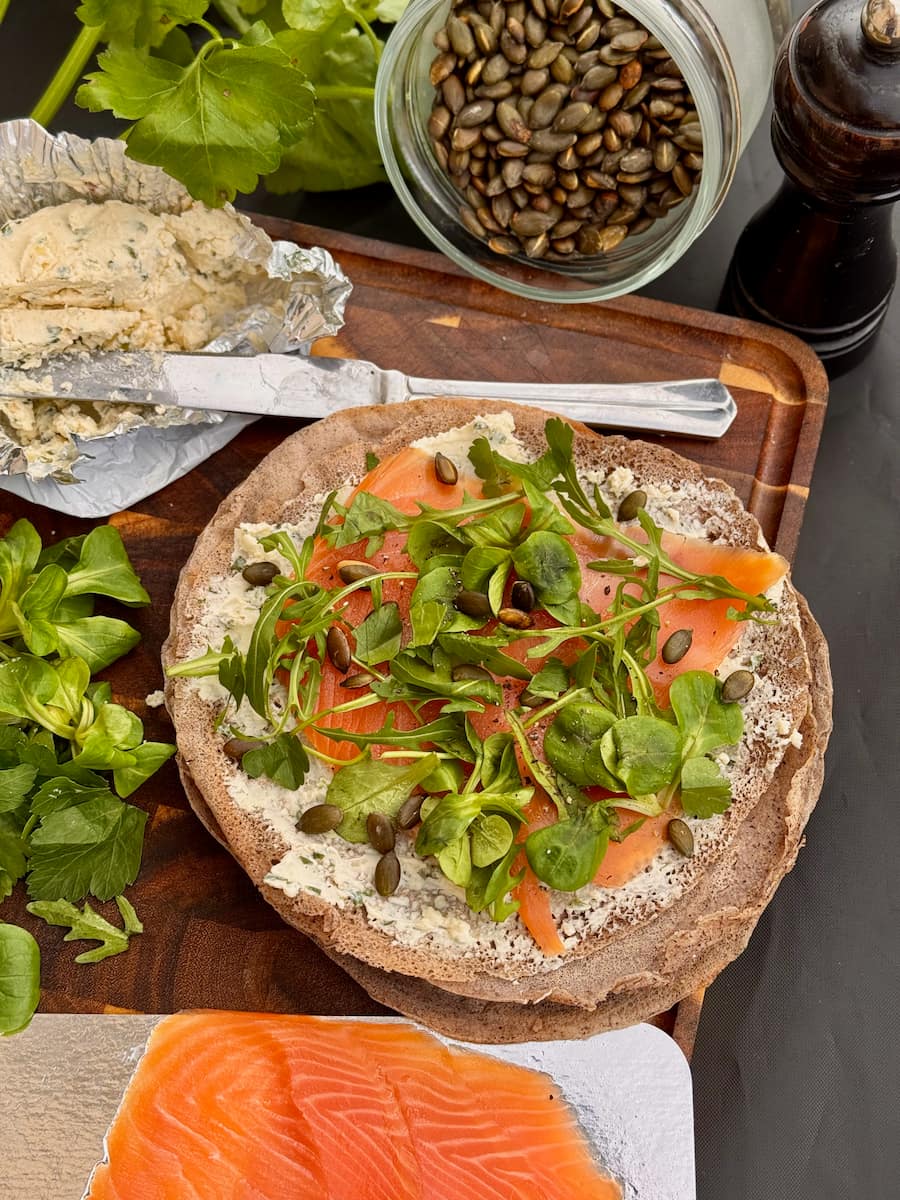 buckwheat wrap spread with cream cheese, then a smoked salmon slice and topped with baby spinach or micro greens and seeds before being rolled