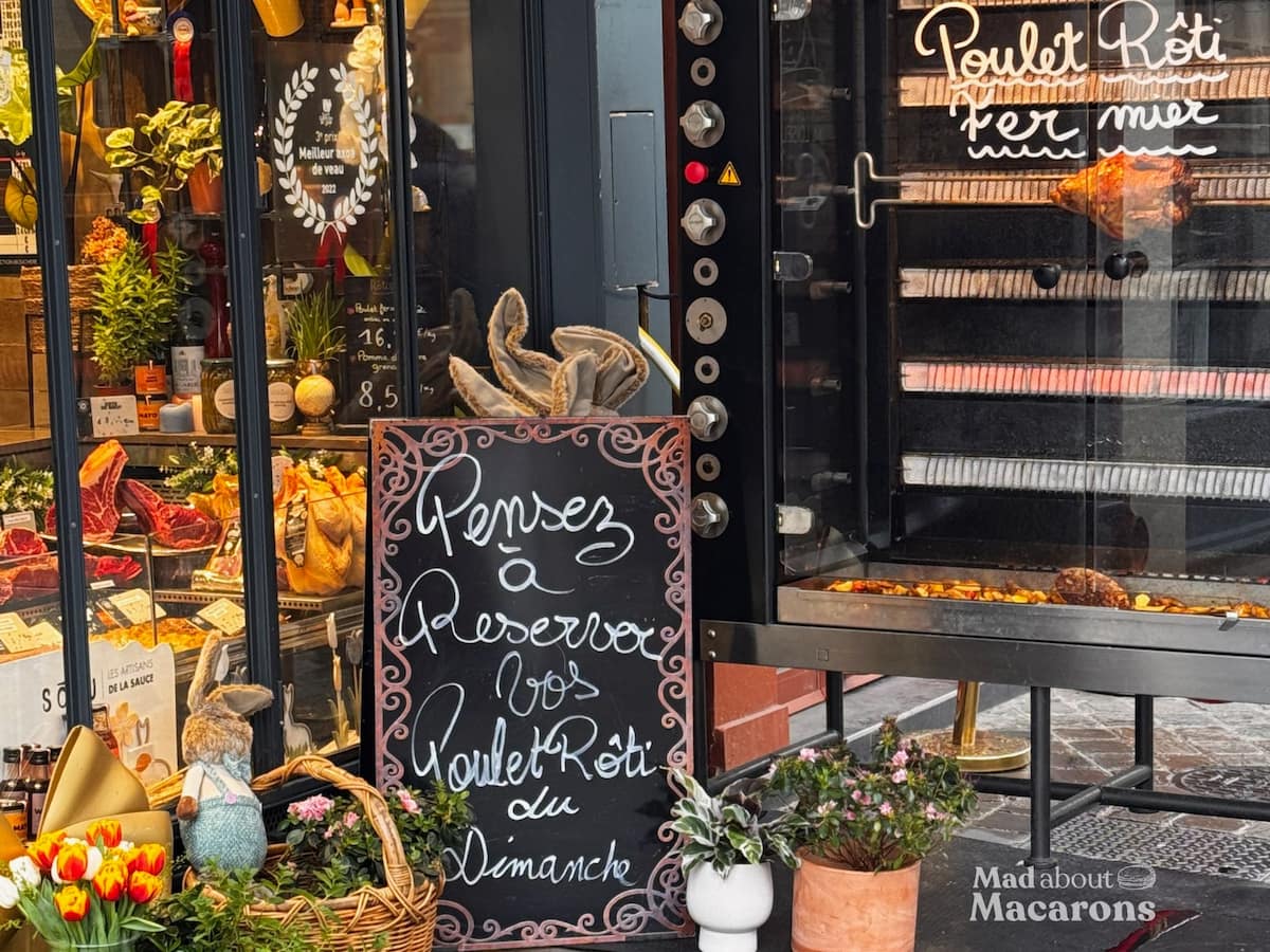 French butcher shop rotisserie with roast chickens turning outside in France