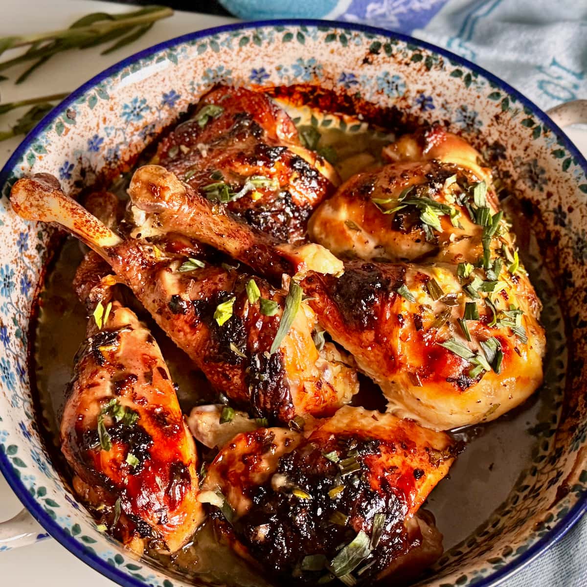 Lemon chicken thighs baked with garlic, herbs and fresh lemon in a rustic French baking dish
