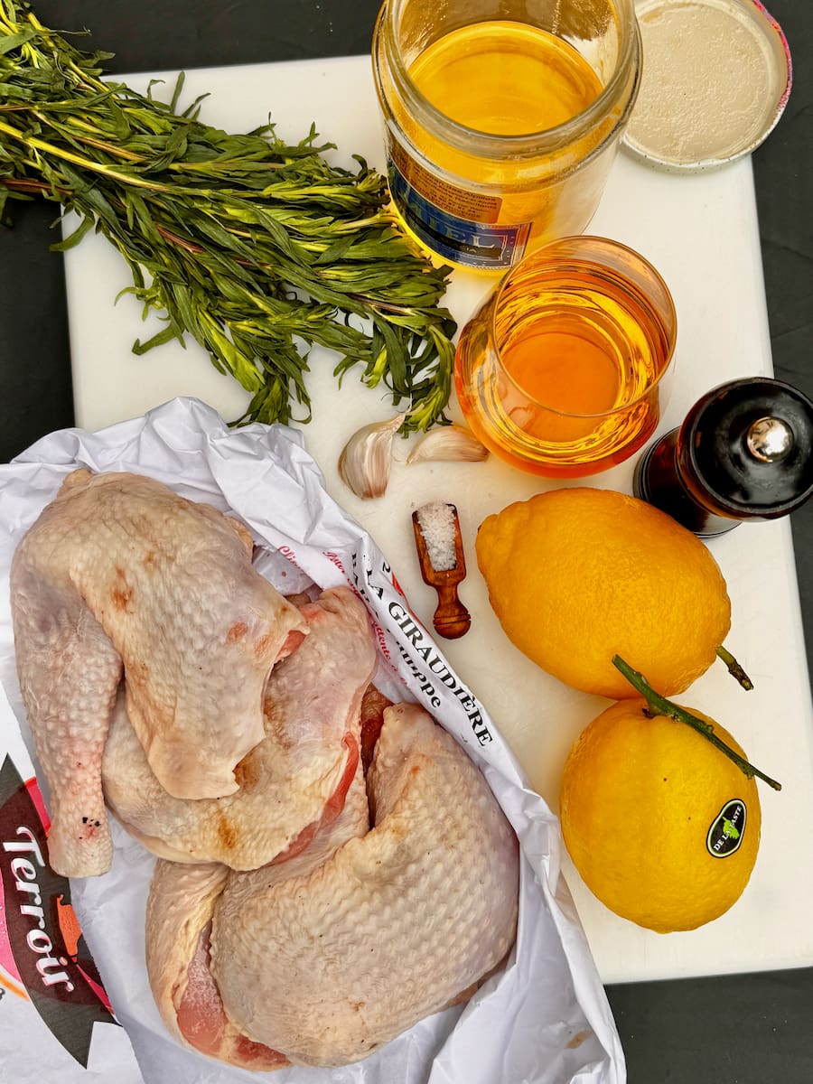 ingredients laid out to make lemon chicken thighs with garlic, fresh tarragon herbs, honey and white wine