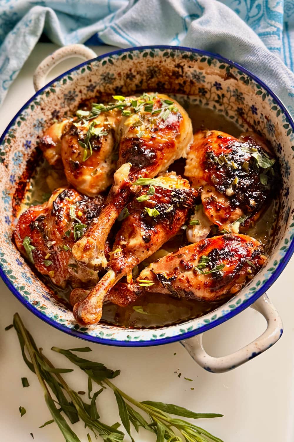 tender lemon chicken in a French oven dish with freshly chopped tarragon herbs