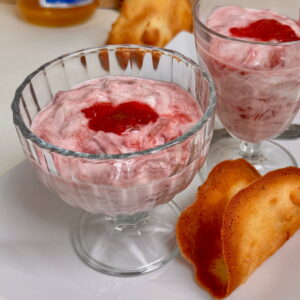 Glass dishes filled with rhubarb fool swirled into Greek yogurt with ginger and honey