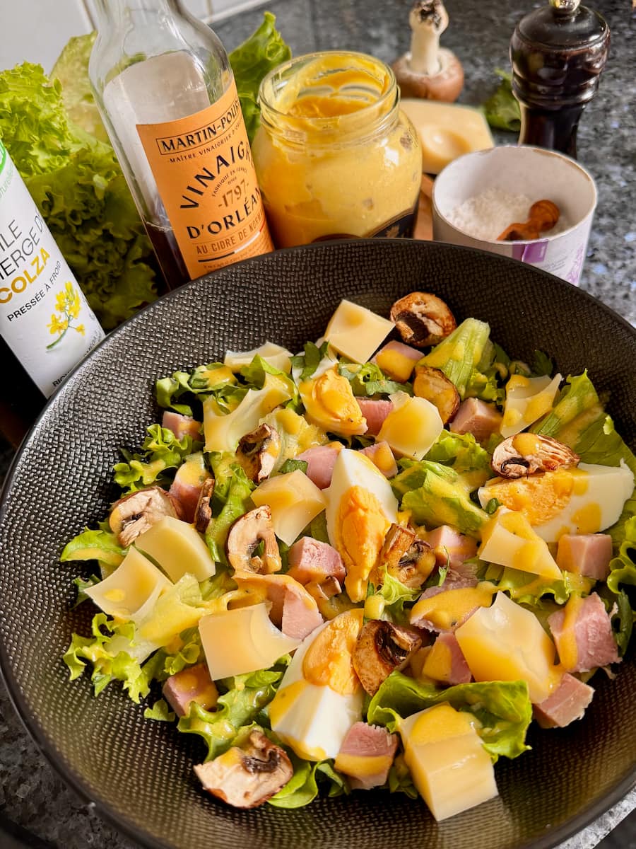 French ham cheese salad with hard boiled egg, curly lettuce and a mustard vinaigrette