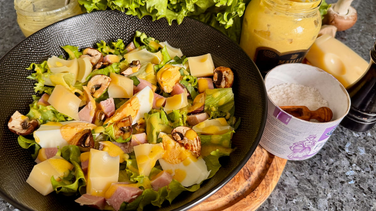 Ham and cheese salad topped with eggs and lettuce, a Parisian classic
