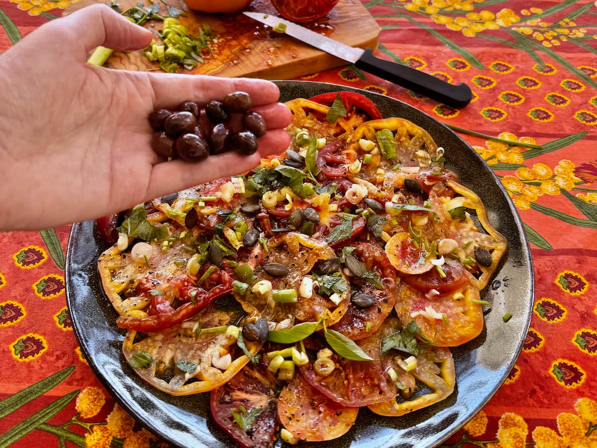 French tomato salad with onions, herbs and topped with Niçoise olives