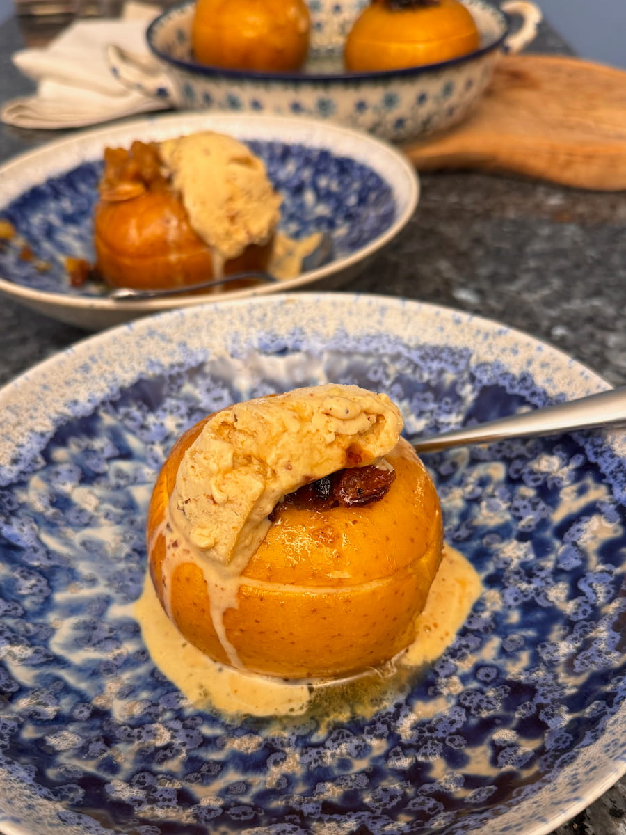 whole baked apples served with ice cream, melting on top in dessert bowls