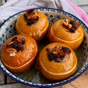 Baked apples recipe that's French, stuffed with raisins, honey and almonds and split at the top in an ovenproof dish