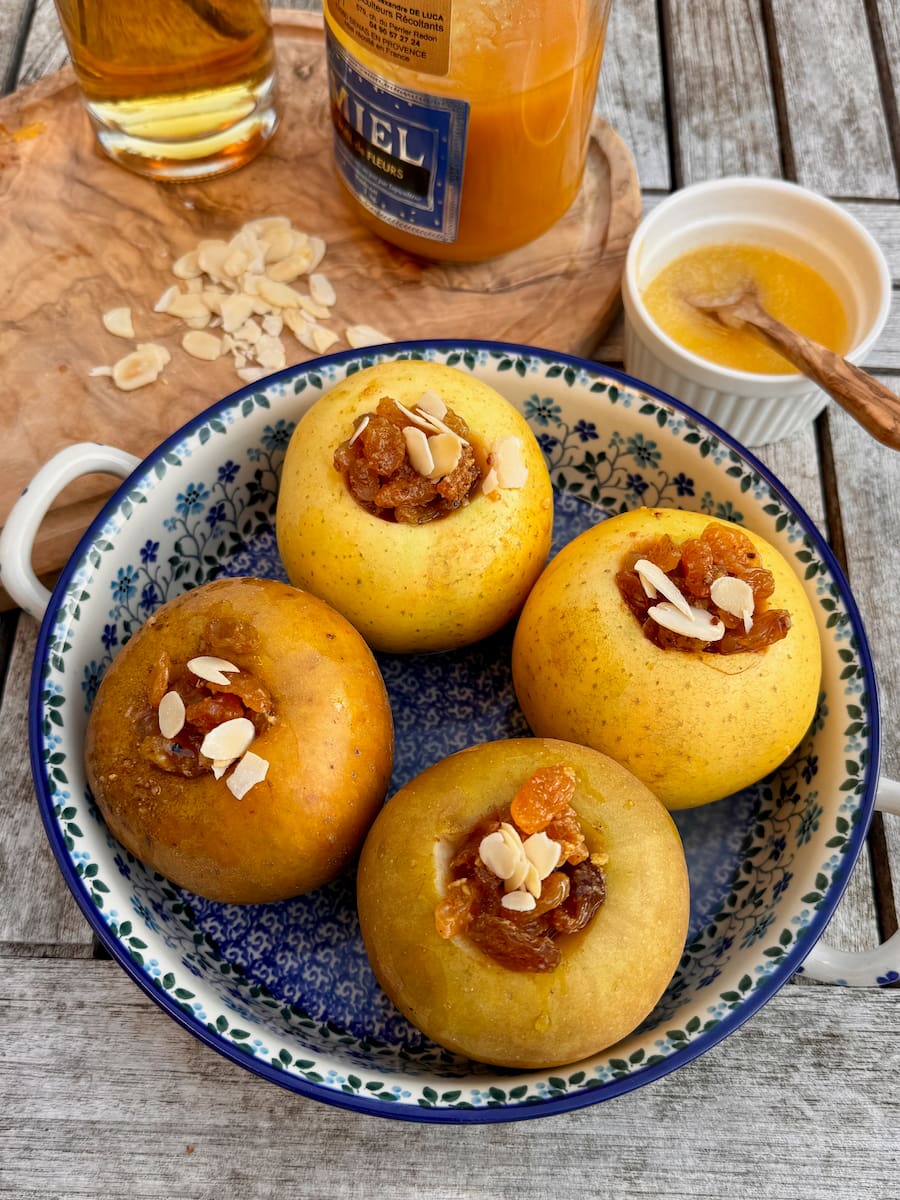 Drizzling honey over whole apples stuffed with the dried-fruit mixture.